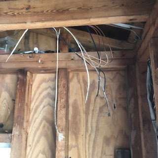Exposed electrical wiring hanging from a wooden ceiling, indicating electrical work by Cherry Valley Plumbing and Electrical in Middleville, MI