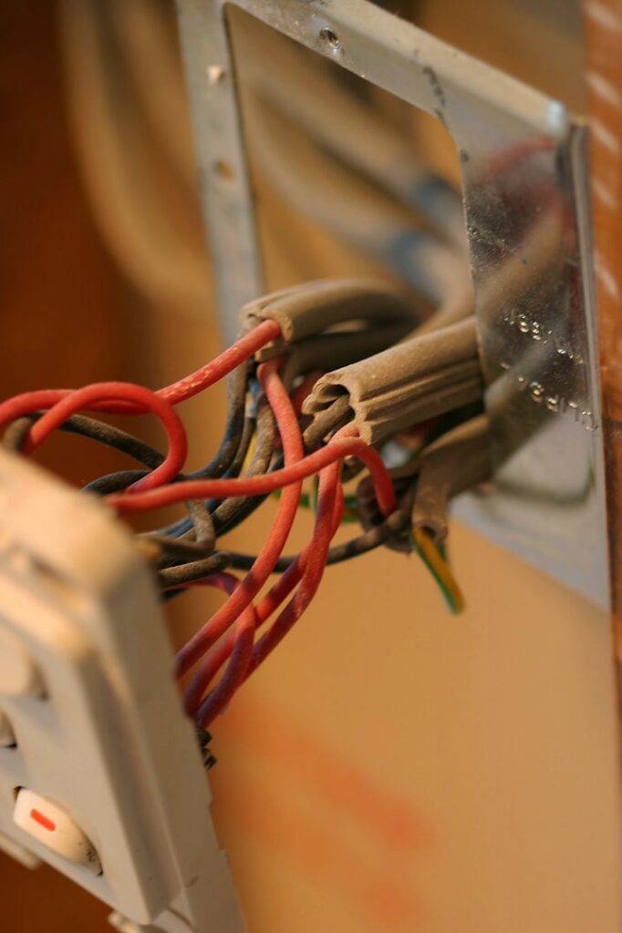 Exposed electrical wiring in a wall switch box, indicating ongoing electrical work by Accuracy Electric Incorporation in Lakewood, CO.