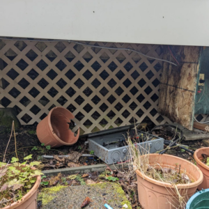 Exposed electrical wiring and an open junction box under a deck, showing a repair or installation in Federal Way, WA by Alt Electric LLC.
