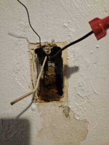 Exposed electrical wiring in a wall box with wire nuts, showing an electrical repair or installation by Elite Electric Company in Melrose Park, IL