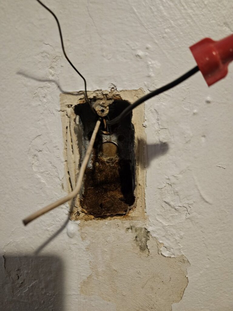 Exposed electrical wiring in a wall box with wire nuts, showing an electrical repair or installation by Elite Electric Company in Melrose Park, IL