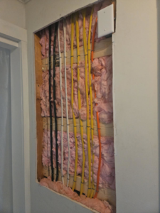 Exposed electrical wiring in wall studs with insulation, showing rough-in work by HLR Electric Company, LLC in Durham, NC.