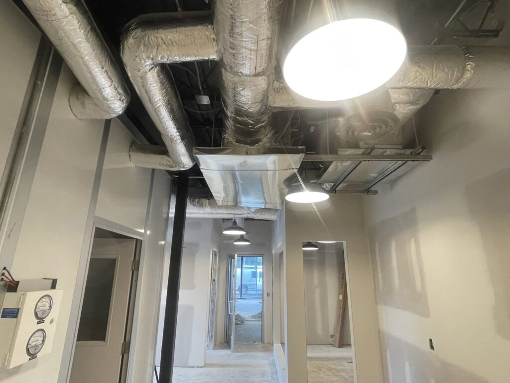 Exposed HVAC ductwork and vents in a commercial building under construction by Elite Home Comfort in Clarksville, TN