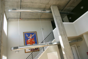 Interior view of a building with exposed rectangular HVAC ductwork installed by KCA Companies, Inc. in Denver, CO