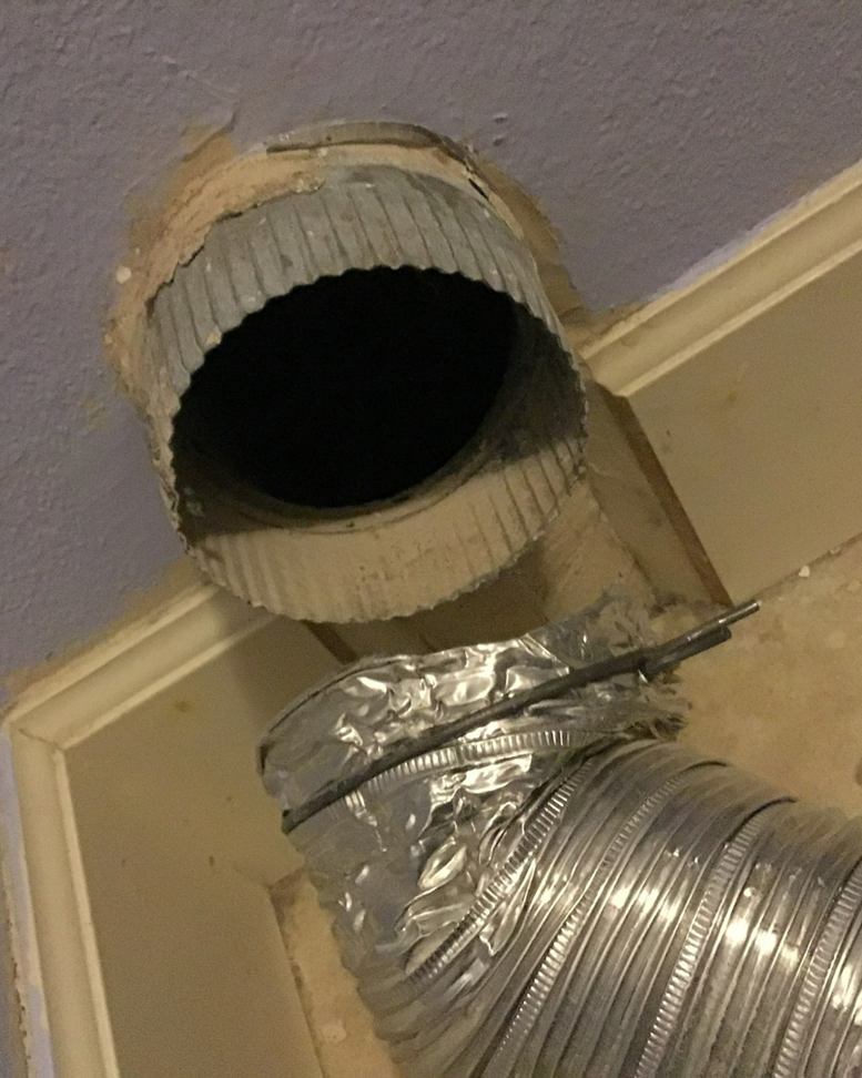 Exposed metal HVAC ductwork, both rigid and flexible, connected to a ceiling opening during installation or repair by KAP'S HVAC in Portland, OR.