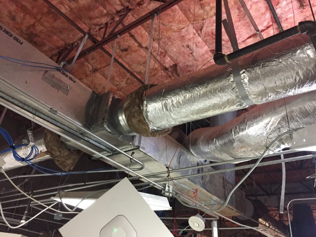 Exposed HVAC ductwork and insulation in a commercial building by Viking Heating and Air Conditioning, LLC in Chandler, AZ