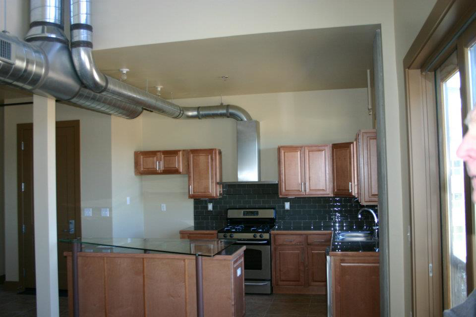 Modern kitchen featuring exposed spiral HVAC ductwork installation by KCA Companies, Inc. in Denver, CO