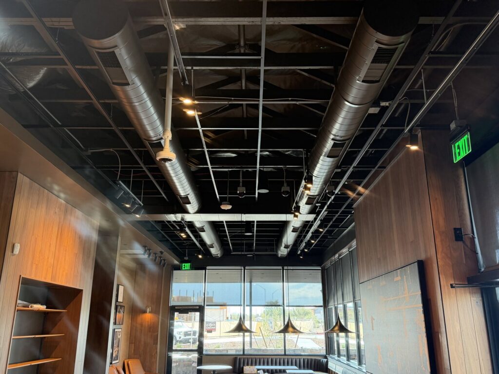 Modern exposed spiral HVAC ductwork visible in a commercial interior completed by Gotham Air LLC in Glendale, AZ.