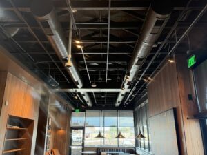 Modern exposed spiral HVAC ductwork visible in a commercial interior completed by Gotham Air LLC in Glendale, AZ.