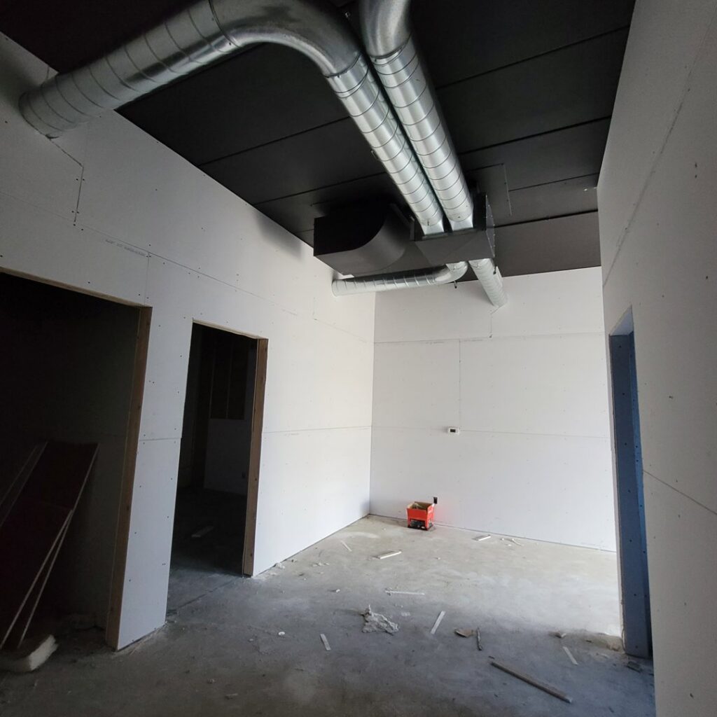 Modern exposed spiral HVAC ductwork installed in a room under construction by Montefusco HVAC in Peoria, IL