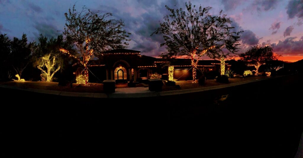 Extensive outdoor Christmas lighting installed on a house and trees by GET LIT Electrical Services LLC in Glendale, AZ.