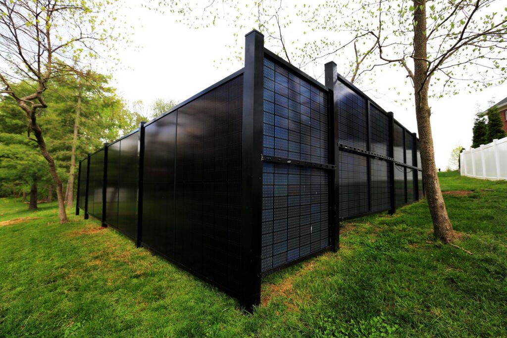 An extensive solar fence installation with blue panels in a residential area by Sol Fence LLC in Evansville, IN.