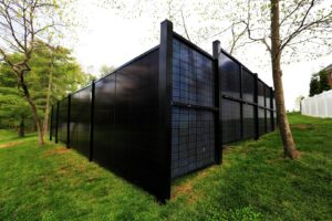 An extensive solar fence installation with blue panels in a residential area by Sol Fence LLC in Evansville, IN.