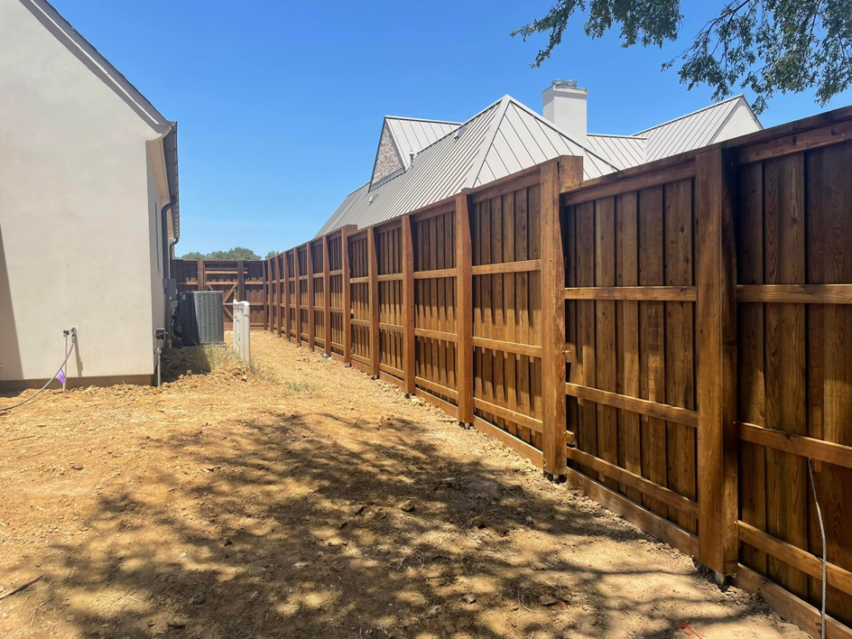 An extensive wood fence line installed along a property boundary by 3M Custom Fence in Lewisville, TX.