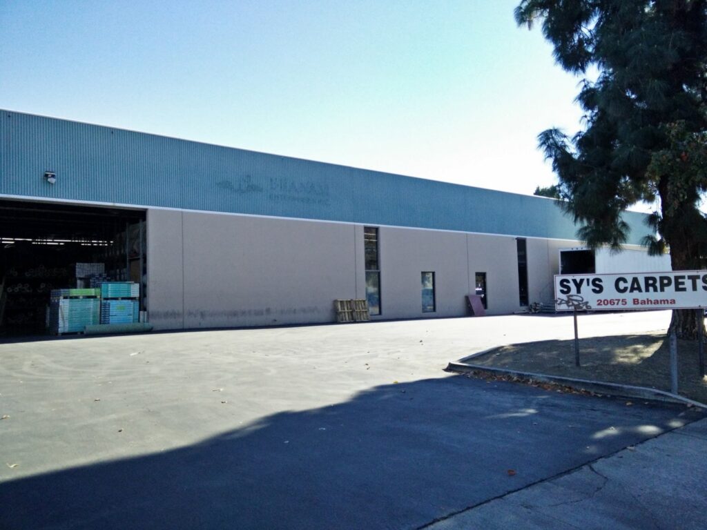 The exterior of the business building with a 'SY'S CARPETS' sign, located in Los Angeles, CA
