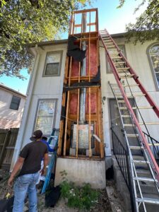 Exterior chimney repair and construction in progress with ladders at a home by The Texan Chimney Sweep San Antonio, TX.