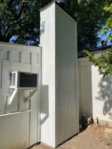 An exterior chimney with new siding or undergoing repair, demonstrating services by HBR Hearth and Chimney in Dallas, TX