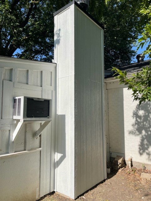 An exterior chimney with new siding or undergoing repair, demonstrating services by HBR Hearth and Chimney in Dallas, TX