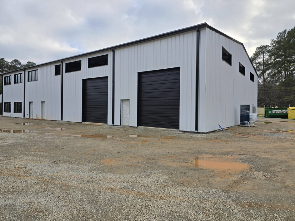 Exterior of a commercial building featuring newly installed black garage doors by Coles Garage Door Service, LLC in West Columbia, SC.