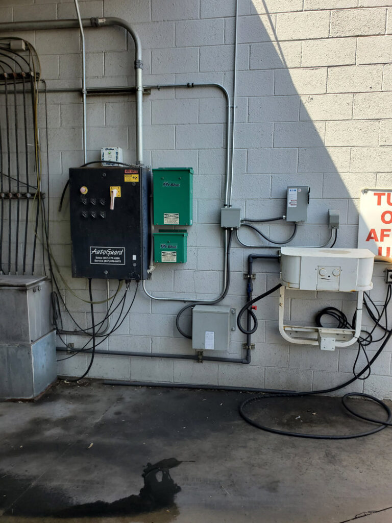 Exterior commercial electrical panels and conduits on a brick wall, installed by TJS Electrical Services Inc in Mesa, AZ.