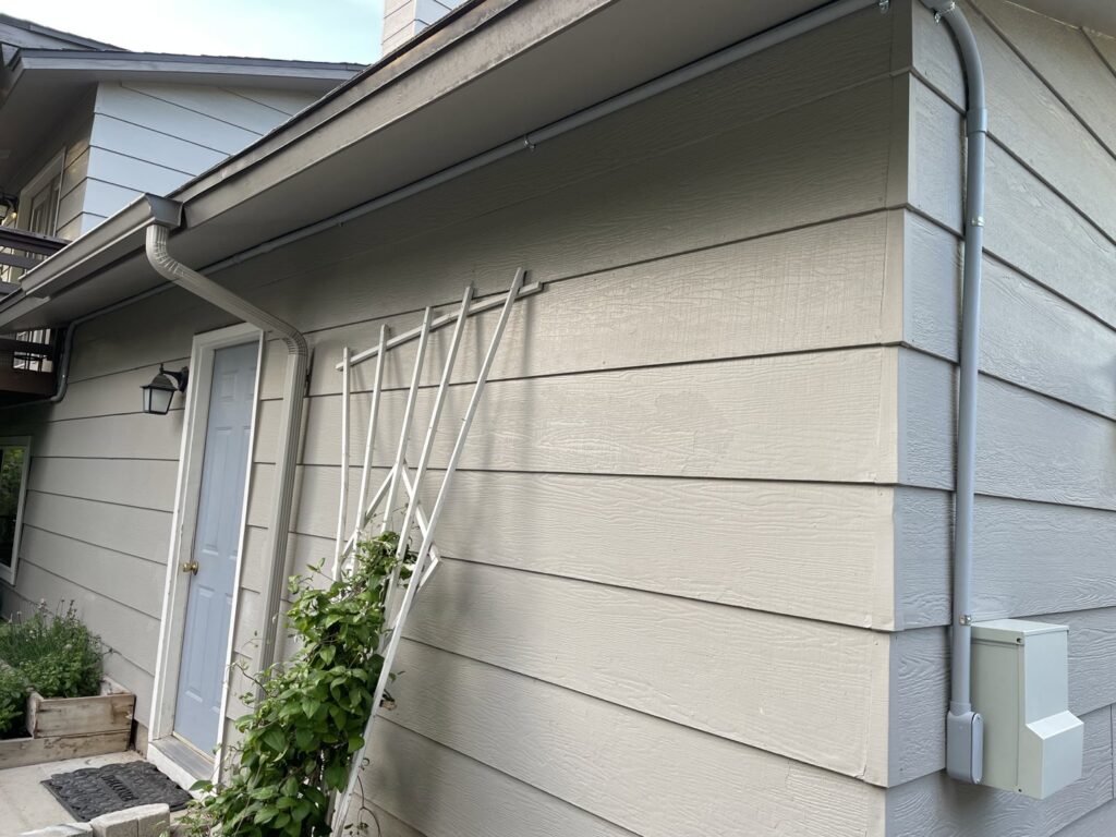 Exterior electrical conduit and junction box installed on the side of a house by All 4 You Electrical in Boise, ID.