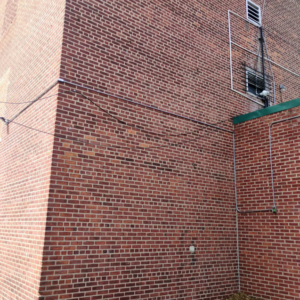 Exterior electrical conduit professionally installed on a brick building by C&J And Sons Multi Services in Newark, NJ.