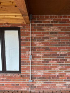 Exterior electrical conduit and junction boxes installed on a brick wall by Fiedler Electric in Higginsville, MO.