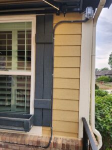Exterior electrical conduit and a junction box neatly installed on the side of a house by Legacy Electric in Westminster, CO.