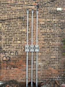 Exterior electrical conduit and junction box installation on a brick wall by Power Electric in De Leon springs, FL.