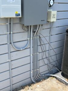Multiple electrical conduits and junction boxes installed on an exterior wall by Safewater Electric in North Charleston, SC.