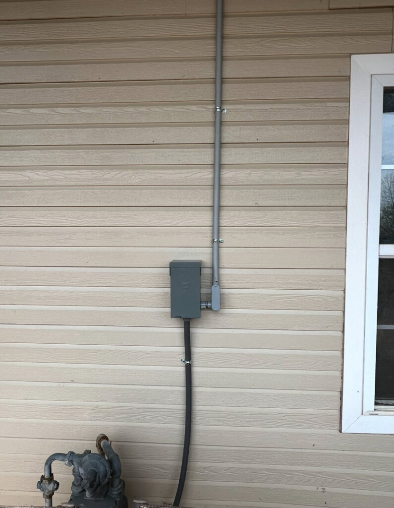 Exterior electrical conduit and a junction box installed on a building by Raschke & Sons Electric in Chattanooga, TN