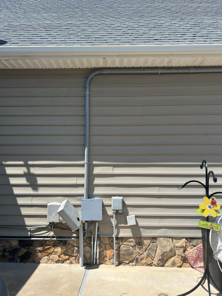 Exterior electrical conduits and wiring installed on the siding of a home, demonstrating work by Kaufman Electric in Greensboro, NC.