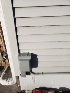 An exterior electrical disconnect box installed on the side of a house by Affordable Electric, LLC in Kearney, NE.