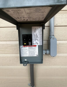 An exterior electrical disconnect box installed on a building by Raschke & Sons Electric in Chattanooga, TN