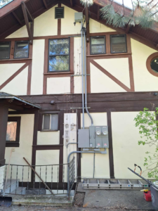 Exterior electrical installation with conduits and meter bases on a house by Candid Electric in Spokane, WA.