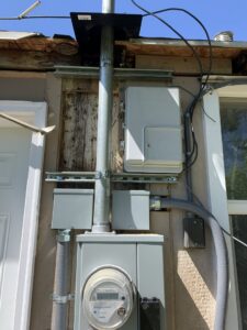 An exterior electrical service mast and meter installation on a building by Copper Canyon Electric in Farmington, UT.