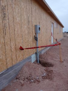 Exterior view of a new construction building showing an electrical meter box and conduit installed by The Specialist Electrical Contractor in Albuquerque, NM.