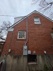 Exterior electrical meter and conduit installation on a brick home by 1st Class Electric in Cranford, NJ.