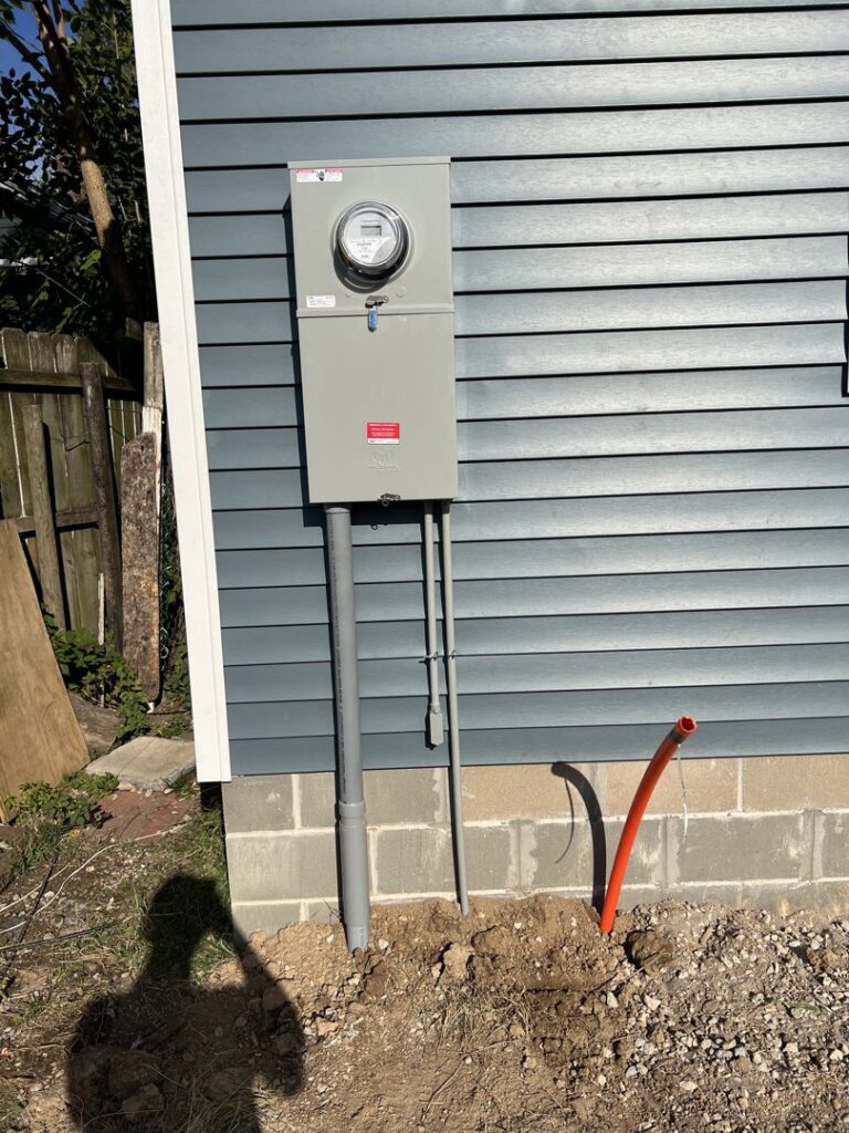 An exterior electrical meter and conduit installation on a new siding wall by F&C Electrical Services LLC in Iowa City, IA.