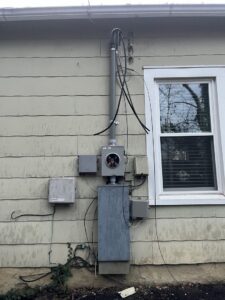 An exterior electrical meter and conduit installation on the side of a house by Mayflower Electric LLC in Knoxville, TN
