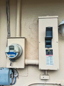 Close-up of an exterior electrical meter and main disconnect panel installed by Weglobal Technologies & EEC Electricals in Deerfield Beach, FL