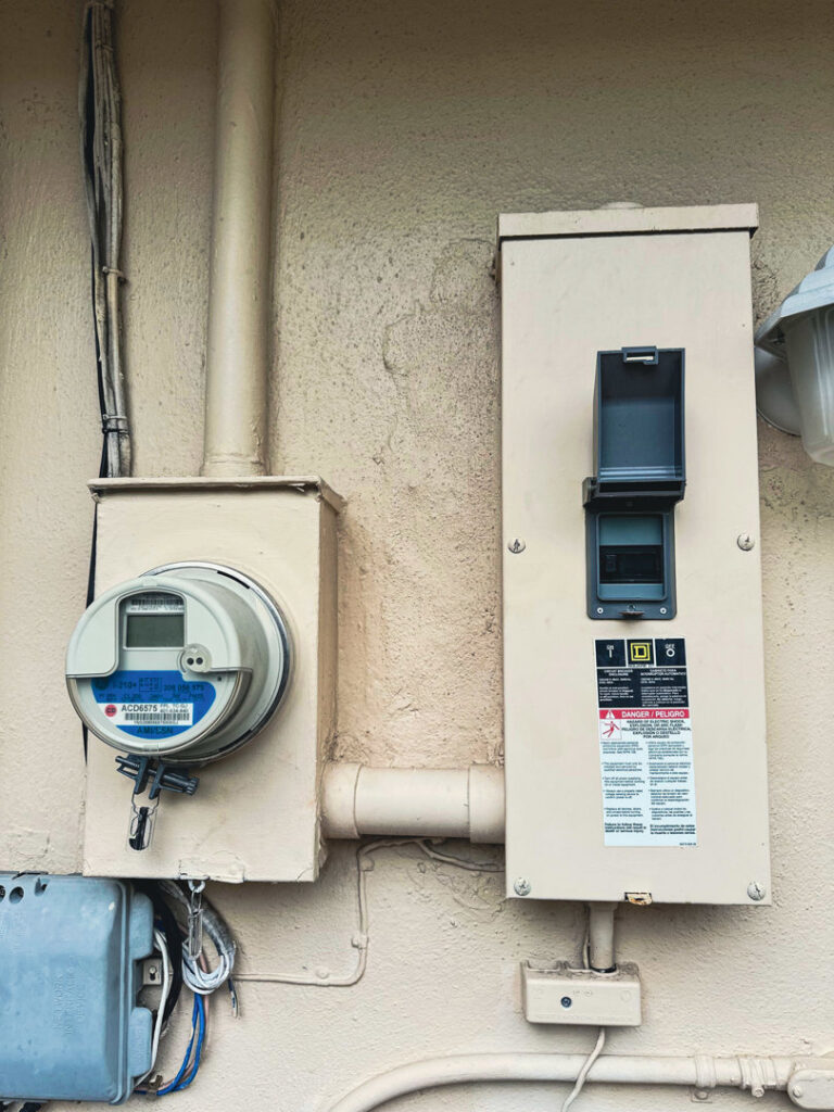 Close-up of an exterior electrical meter and main disconnect panel installed by Weglobal Technologies & EEC Electricals in Deerfield Beach, FL