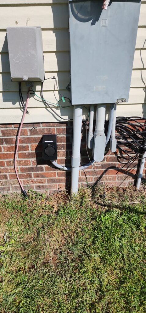 Exterior electrical meter and an installed EV charging outlet on a brick wall by Right Electrical Services LLC in Raleigh, NC.
