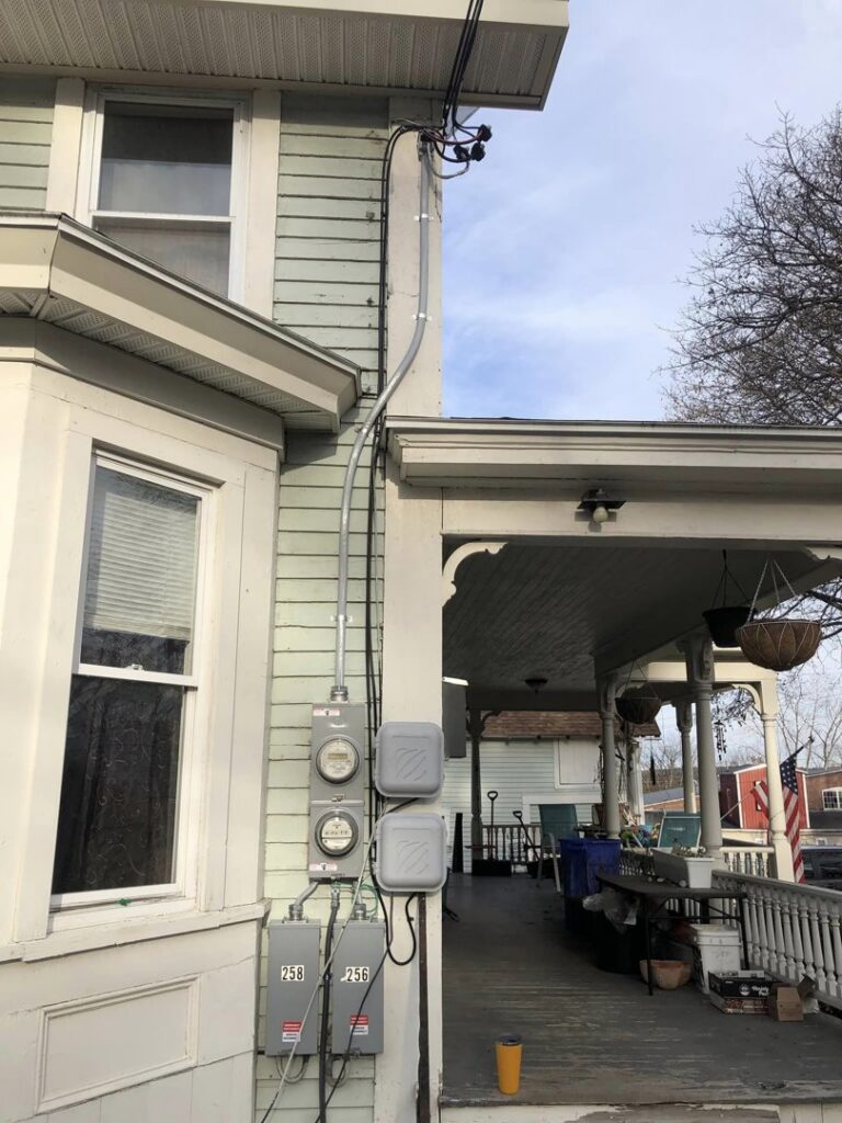 Exterior electrical meters and conduit installed on a residential building by Bacon Electric, LLC in Concord, NH.