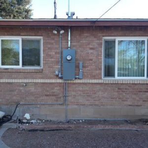 An exterior electrical meter panel and conduit professionally installed on a brick building by Certified Electrician Albuquerque NM.