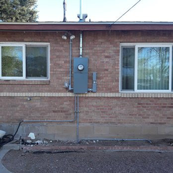 An exterior electrical meter panel and conduit professionally installed on a brick building by Certified Electrician Albuquerque NM.