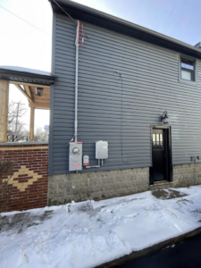 Exterior view of a house with electrical meter and service entrance installed by Richard A. Gibbons in Dracut, MA.