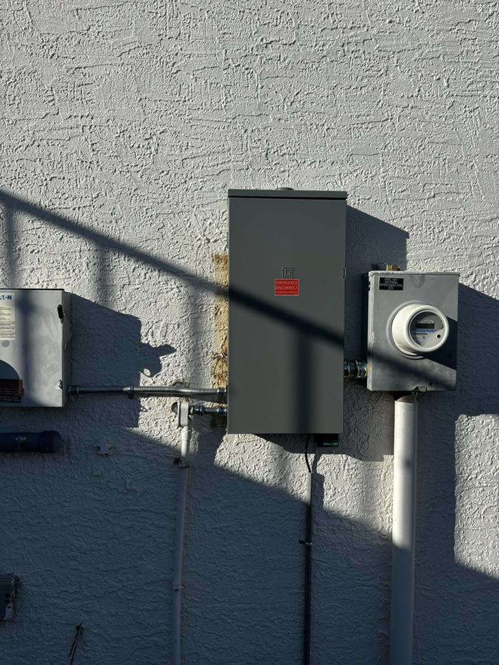 An exterior electrical meter and main panel installed on a building wall by Flores power solutions in El Paso, TX.