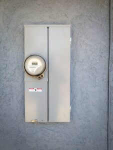 An exterior electrical meter panel mounted on a textured grey wall, installed by Muse Electricians in Los Angeles, CA.