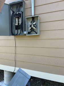 Exterior electrical meter and service panel installation on the side of a building by Ultralight Electric in Houston, TX.